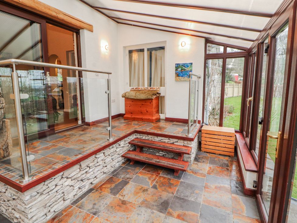 A conservatory with glass railing and wooden chest at Beech Brae in Levens