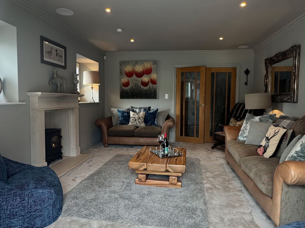A living room with a sofa, coffee table, and fireplace at Johns Cottage in Harrogate