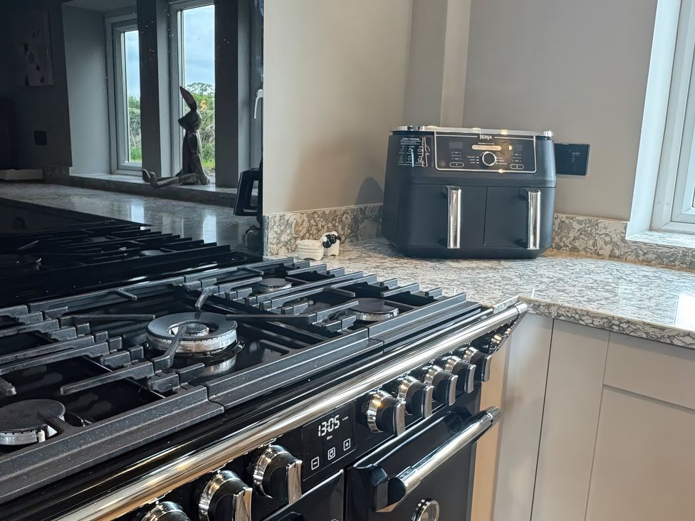A kitchen with a gas stove and an air fryer at Johns Cottage in Harrogate