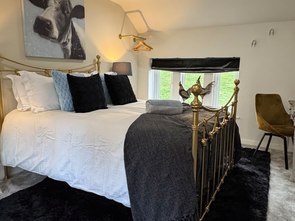 A bedroom with a bed and chair at Johns Cottage in Harrogate