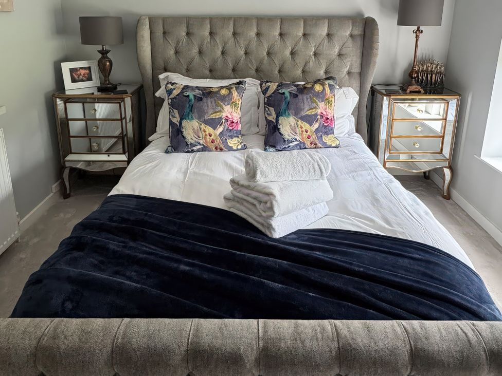 A bedroom with a large bed and bedside tables at Johns Cottage in Harrogate
