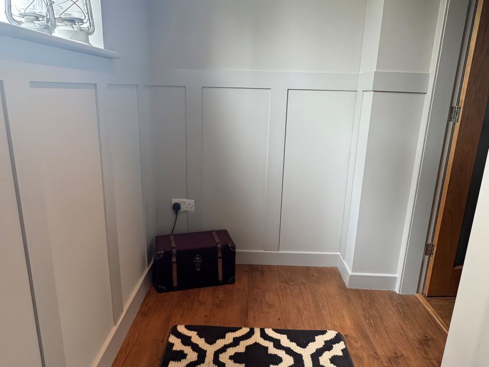 An entryway with a trunk and a rug at Johns Cottage in Harrogate