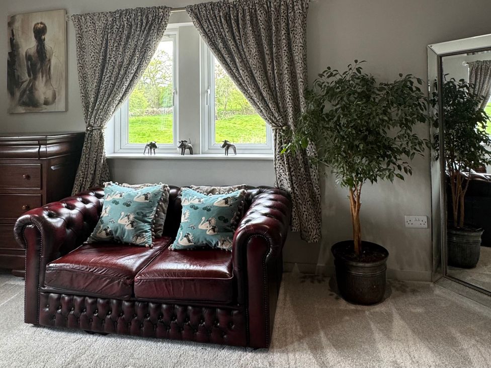 A living room with a sofa and cushions at Johns Cottage in Harrogate