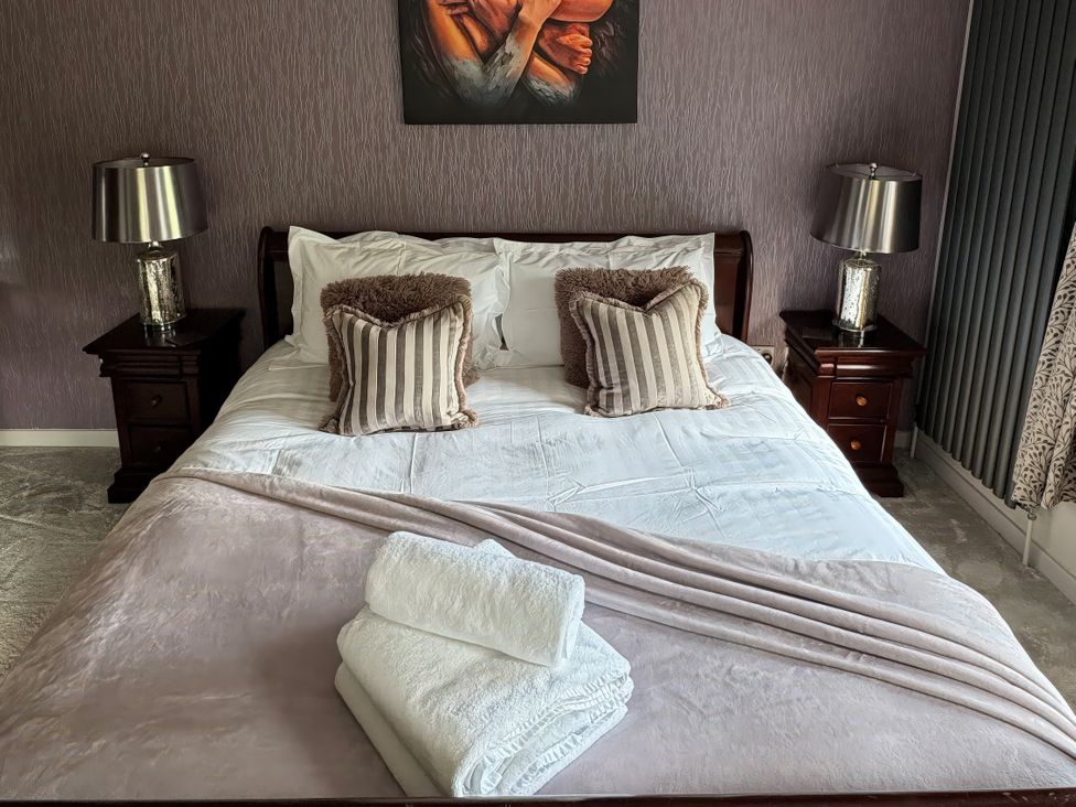 A bedroom with a bed and bedside tables at Johns Cottage in Harrogate