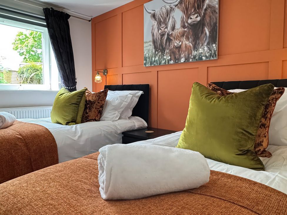 A bedroom with two beds and animal wall art at Johns Cottage in Harrogate