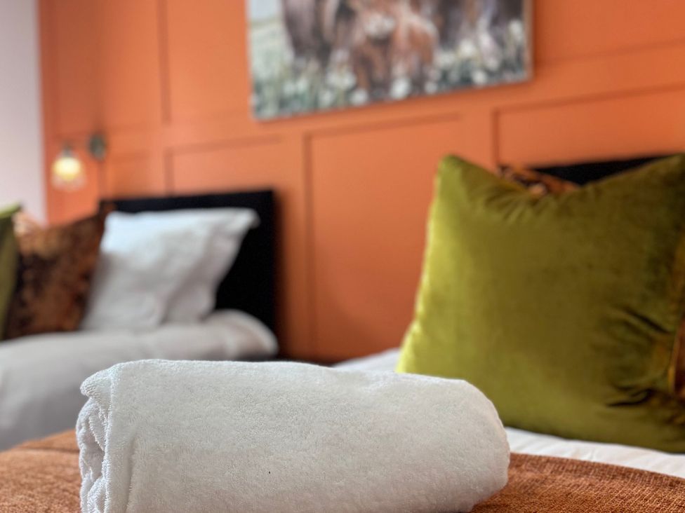 A bedroom with a towel on a bed at Johns Cottage in Harrogate
