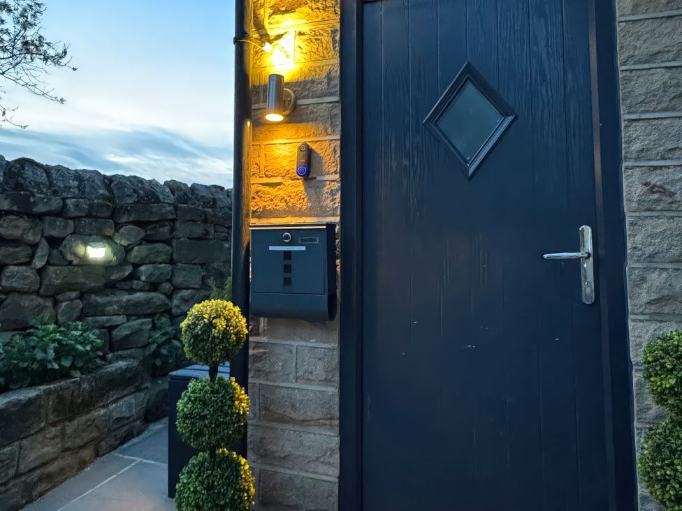 An entrance with a front door and mailbox at Johns Cottage in Harrogate