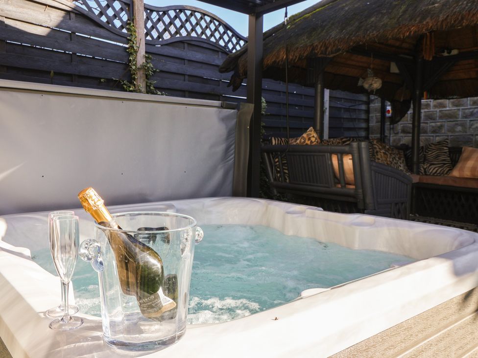 A hot tub with champagne and flutes at Johns Cottage in Hampsthwaite