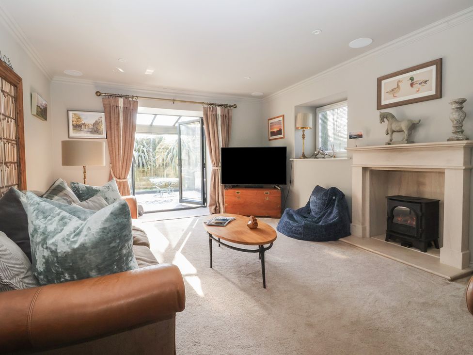 A living room with a television and a fireplace at Johns Cottage in Hampsthwaite