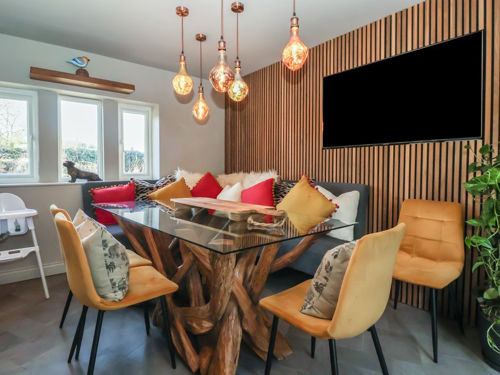 A dining room with a glass table and chairs at Johns Cottage in Hampsthwaite