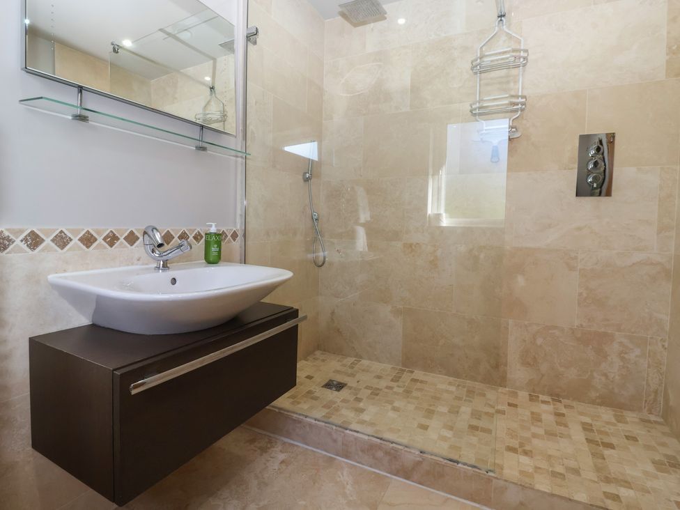 A bathroom with a sink and shower at Johns Cottage in Hampsthwaite