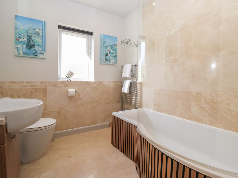 A bathroom with a bathtub, toilet, and sink at Johns Cottage in Hampsthwaite
