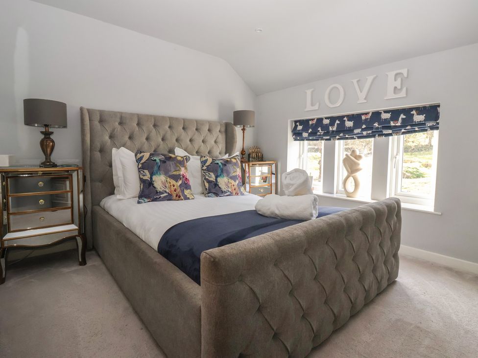 A bedroom with a bed and bedside table at Johns Cottage in Hampsthwaite