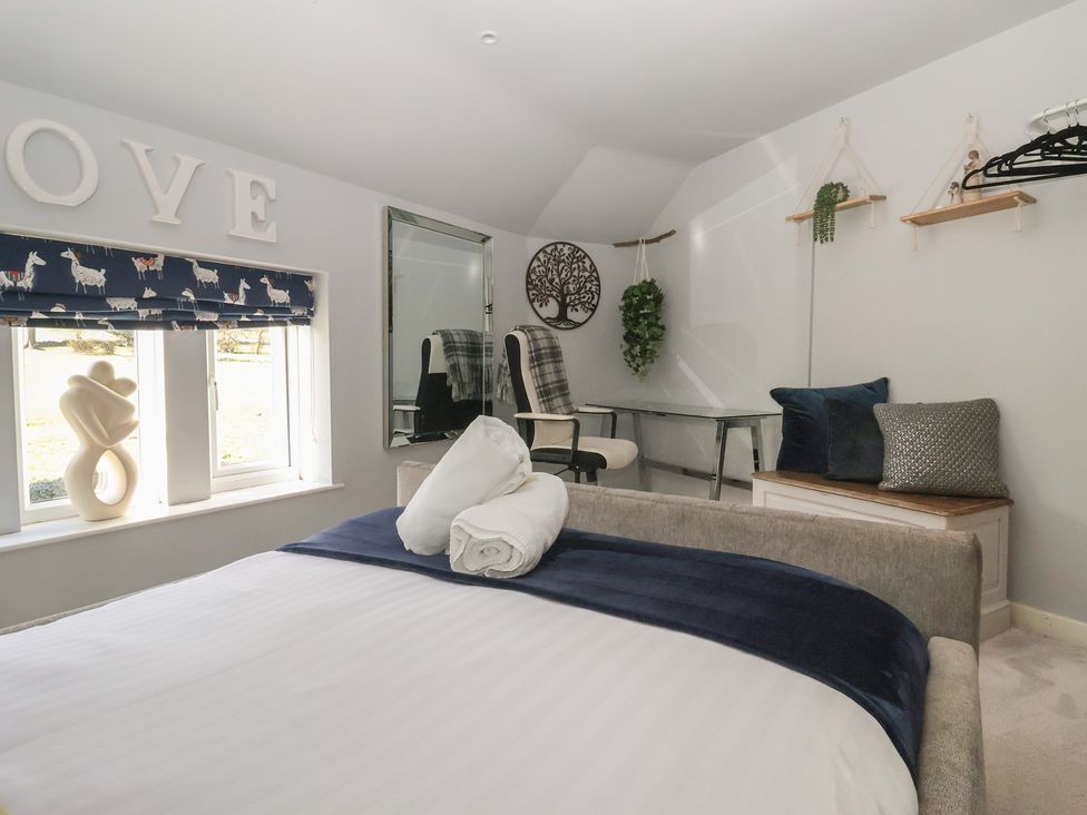 A bedroom with a bed and desk at Johns Cottage in Hampsthwaite