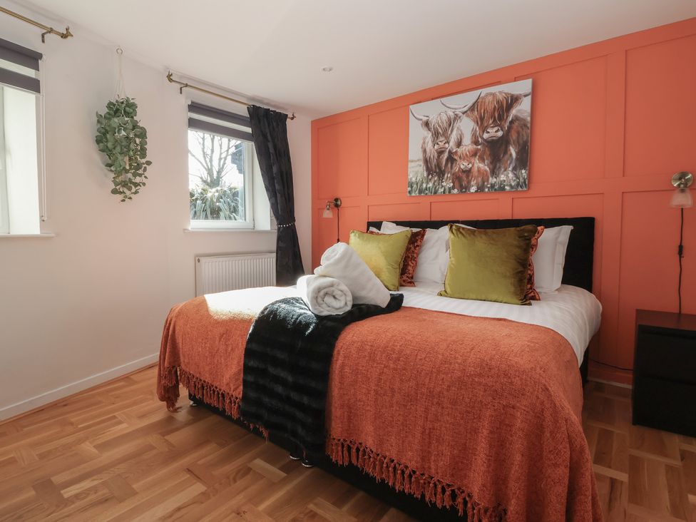 A bedroom with a bed and wall art at Johns Cottage in Hampsthwaite