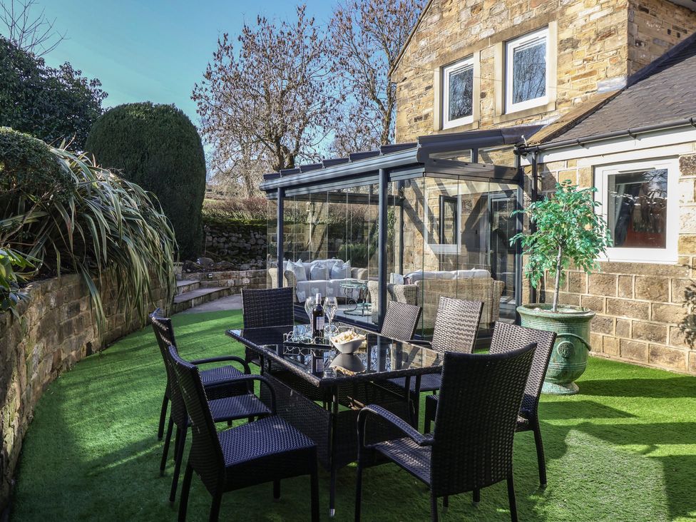 A garden with a table and chairs at Johns Cottage in Hampsthwaite