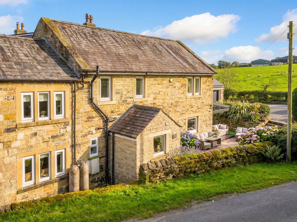 A stone house with garden furniture at Johns Cottage in Hampsthwaite