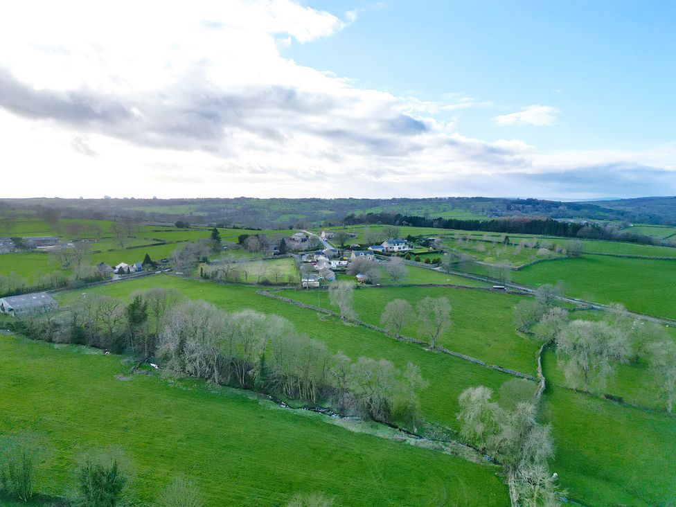 A rural landscape with fields, trees, and houses at Johns Cottage in Hampsthwaite