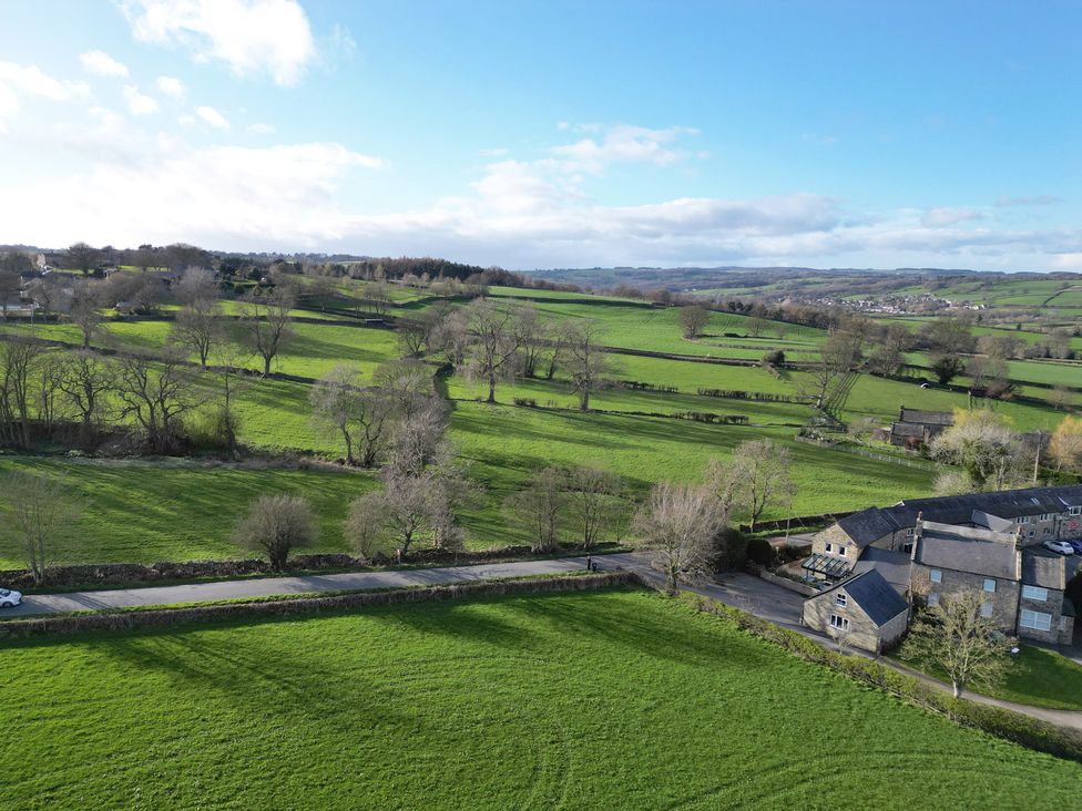 A view of fields and trees near houses at Johns Cottage in Hampsthwaite
