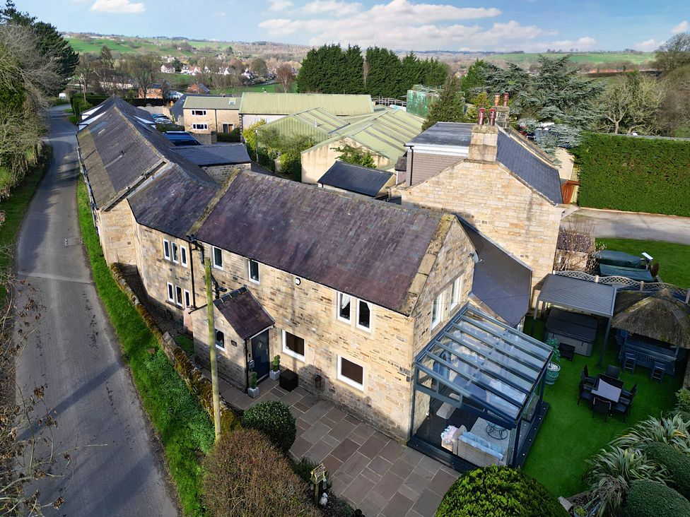 An outdoor view of a house with a garden at Johns Cottage in Hampsthwaite