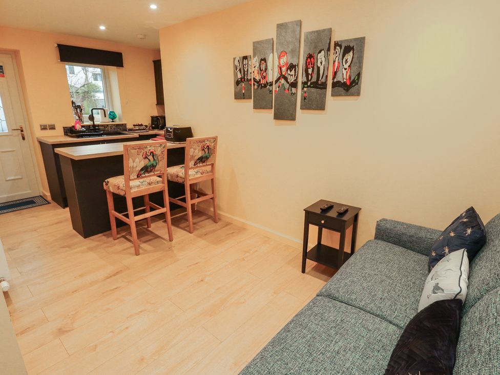 A living room with a sofa and bar counter at The Nook in 
