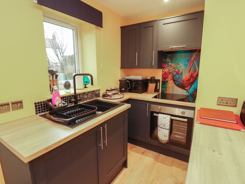 A kitchen with cabinets and appliances at The Nook in 