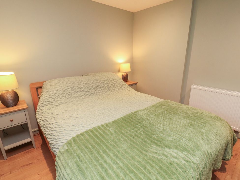 A bedroom with a bed and two lamps at The Nook in 