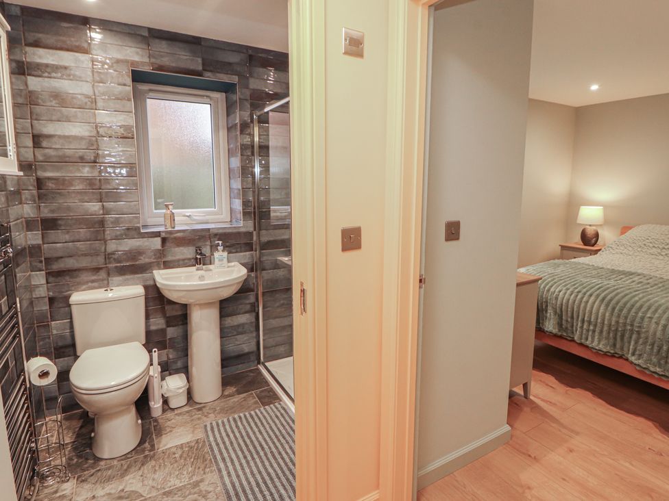 A bathroom with a sink and toilet and a bedroom visible at The Nook