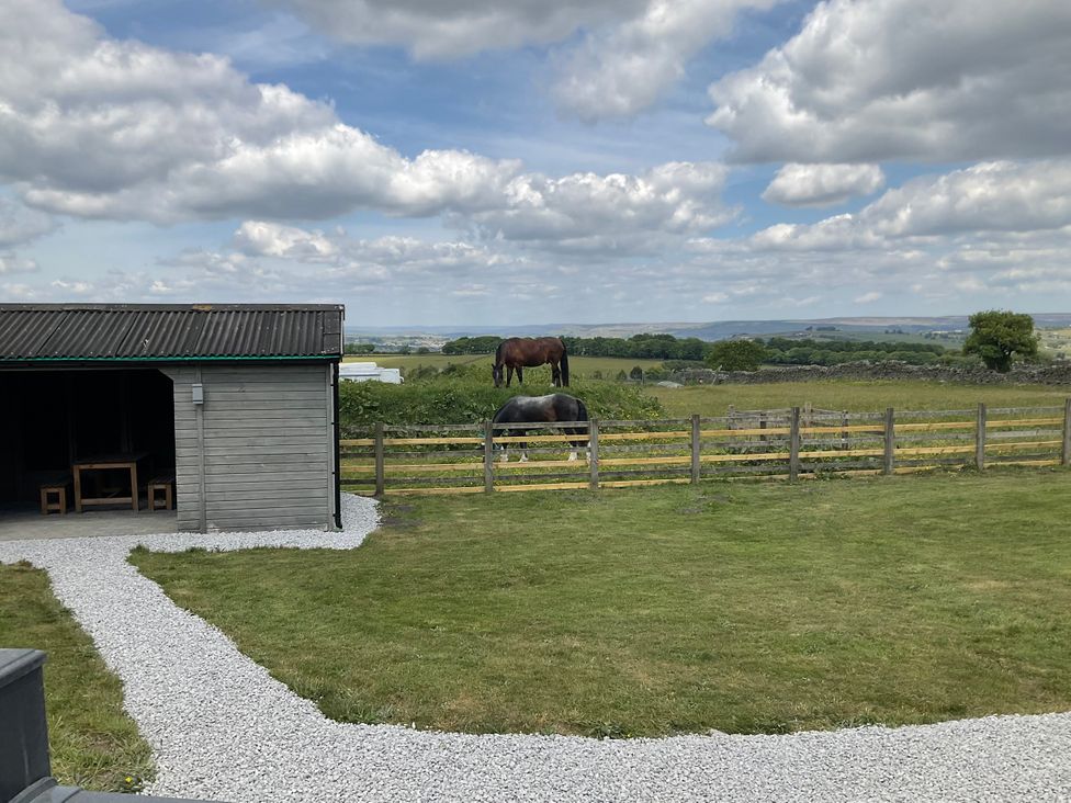 A view of horses grazing near a shed at Little Acre in Oxenhope