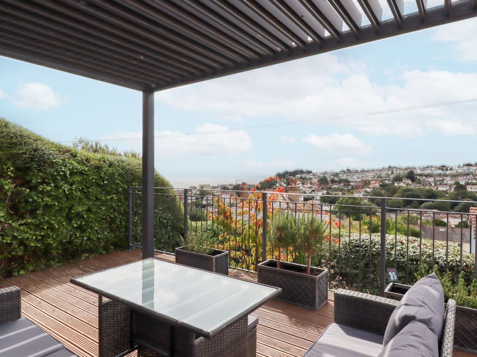 An outdoor patio with a table and chairs overlooking the sea at 15 Summerland Avenue Dawlish