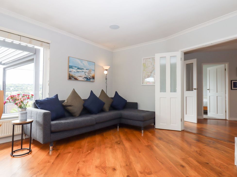 A living room with a sofa and lamp at 15 Summerland Avenue Dawlish