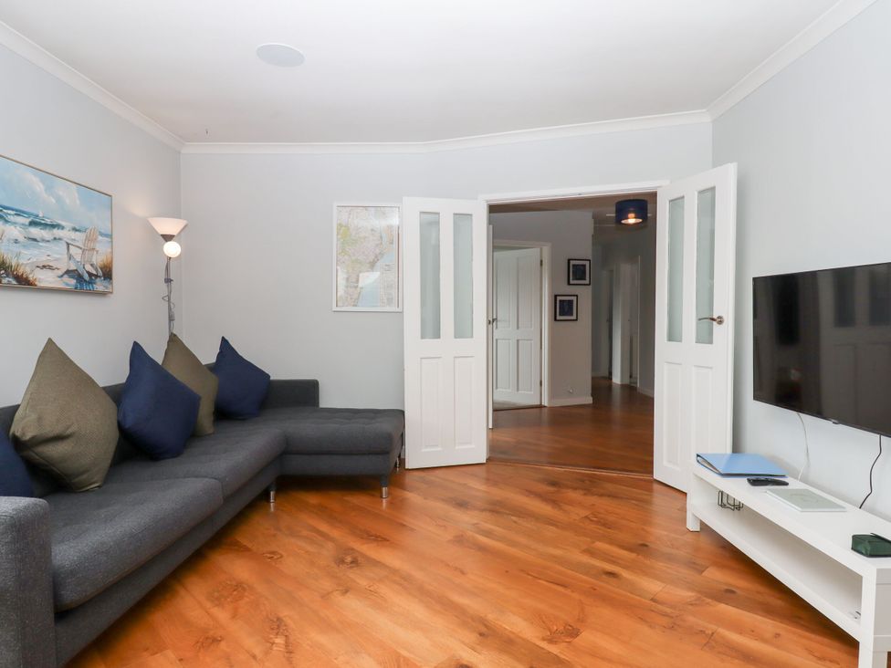 A living room with a sofa and television at 15 Summerland Avenue Dawlish