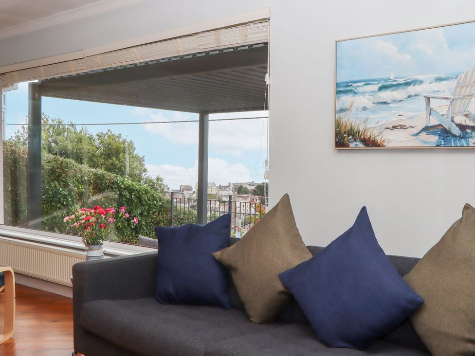 A living room with a view and cushions on a couch at 15 Summerland Avenue Dawlish