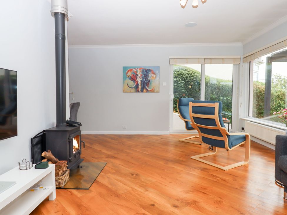 A living room with a stove and blue chairs at 15 Summerland Avenue, Dawlish