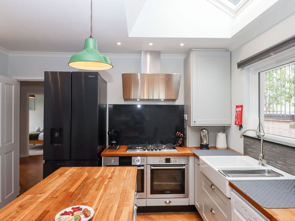 A kitchen with a refrigerator, stove, and sink at 15 Summerland Avenue Dawlish