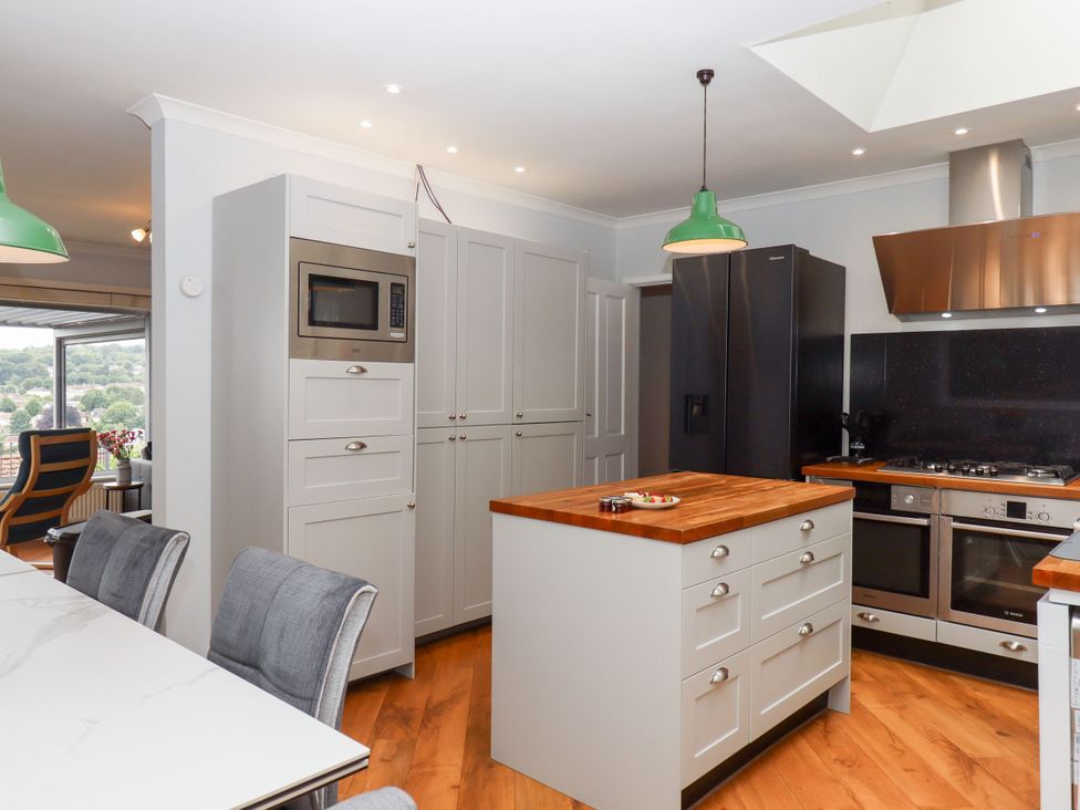 A kitchen with a refrigerator, microwave, and cooking range at 15 Summerland Avenue Dawlish