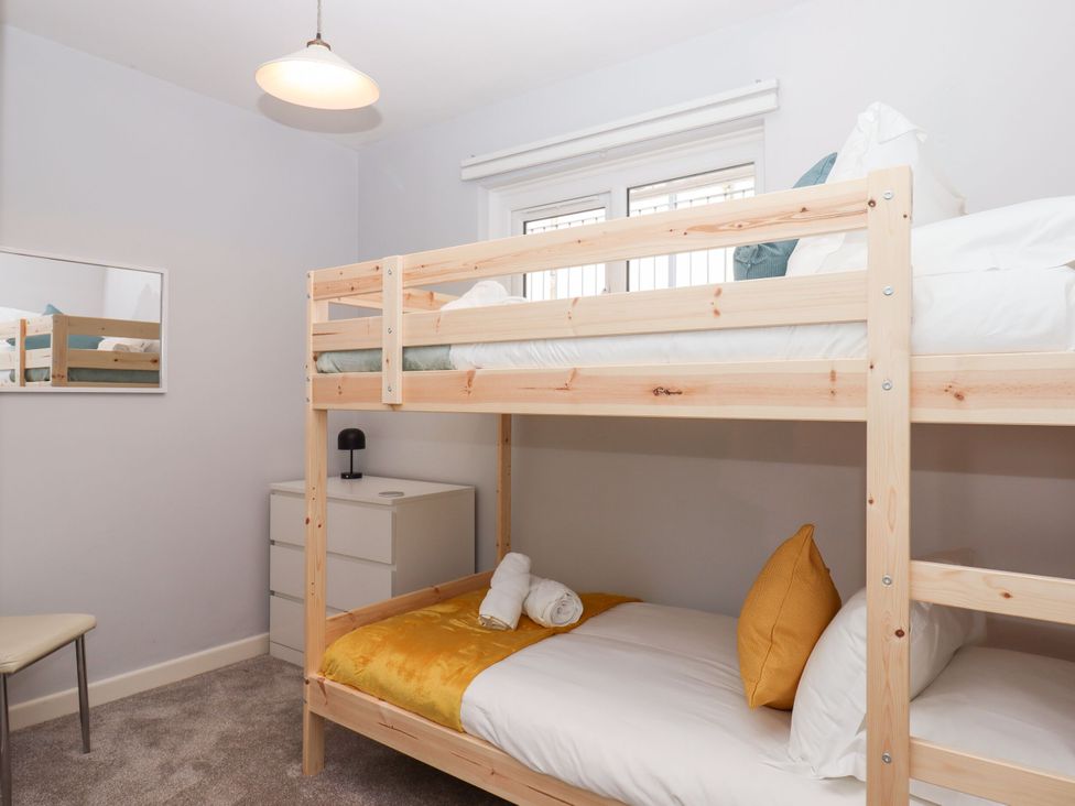 A bedroom with a bunk bed and a single bed at 15 Summerland Avenue Dawlish