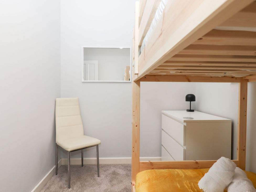 A bedroom with a bunk bed and chair at 15 Summerland Avenue Dawlish
