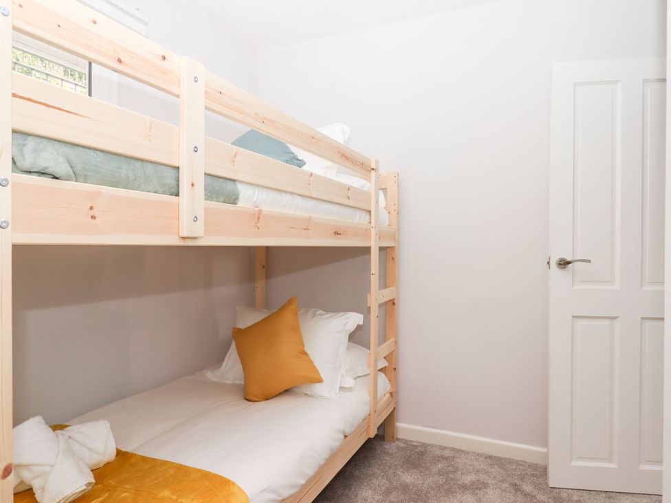 A bedroom with a bunk bed and towels at 15 Summerland Avenue, Dawlish