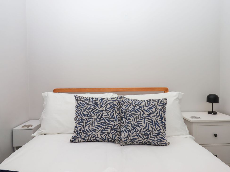 A bedroom with a bed and nightstand at 15 Summerland Avenue Dawlish