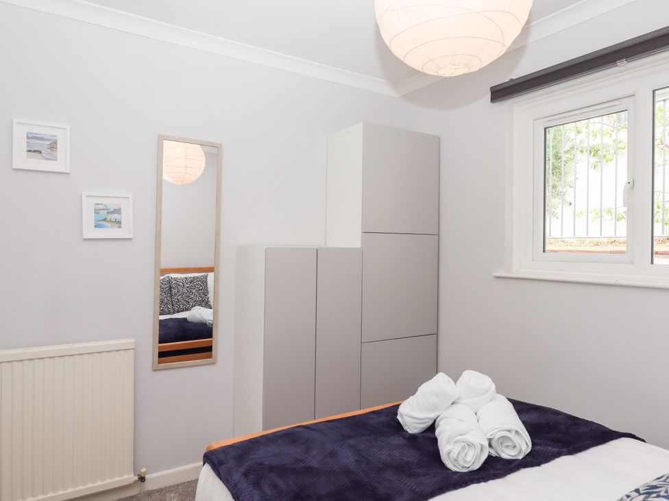 A bedroom with a bed and wardrobe at 15 Summerland Avenue Dawlish