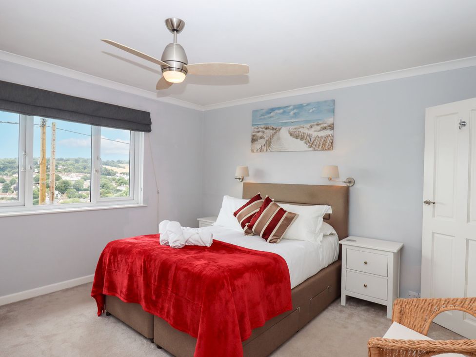 A bedroom with a bed and a bedside table at 15 Summerland Avenue in Dawlish