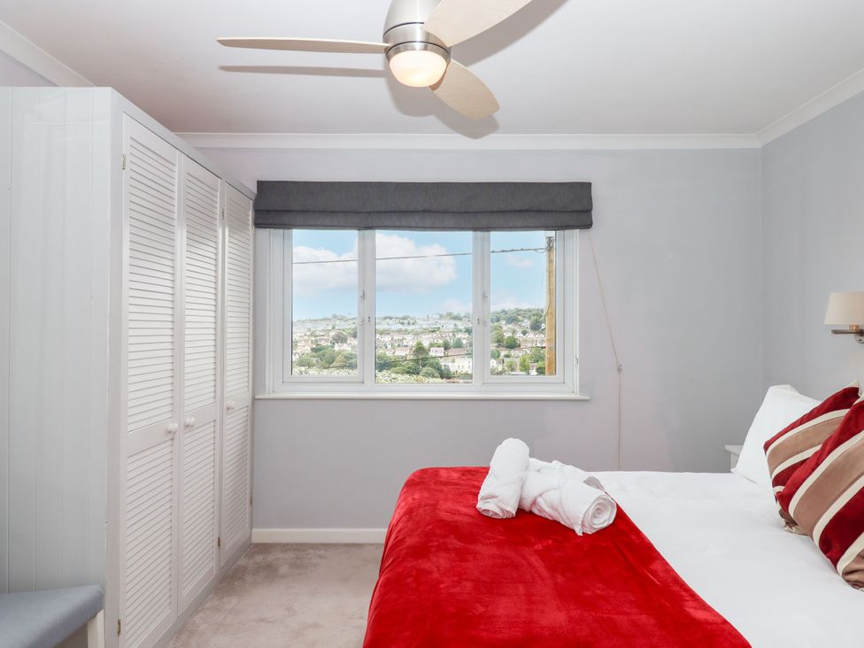 A bedroom with a bed and wardrobe at 15 Summerland Avenue in Dawlish