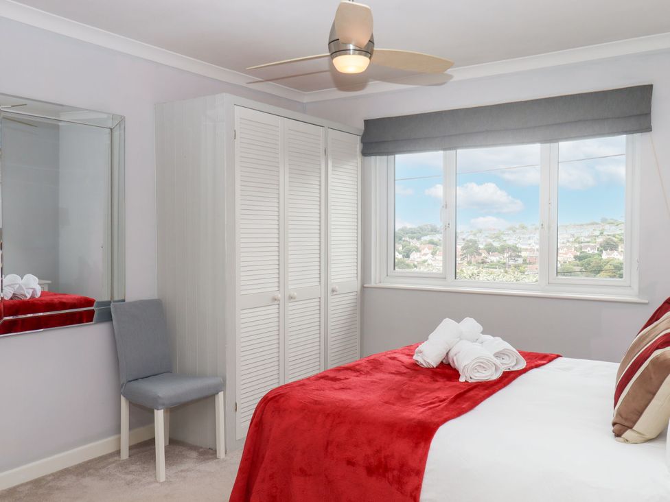 A bedroom with a bed and wardrobe at 15 Summerland Avenue, Dawlish