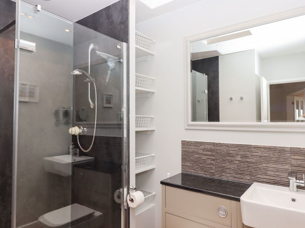 A bathroom with shower, sink, and shelves at 15 Summerland Avenue, Dawlish