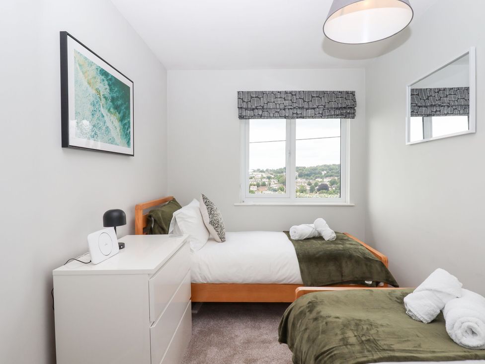A bedroom with two beds and a dresser at 15 Summerland Avenue, Dawlish