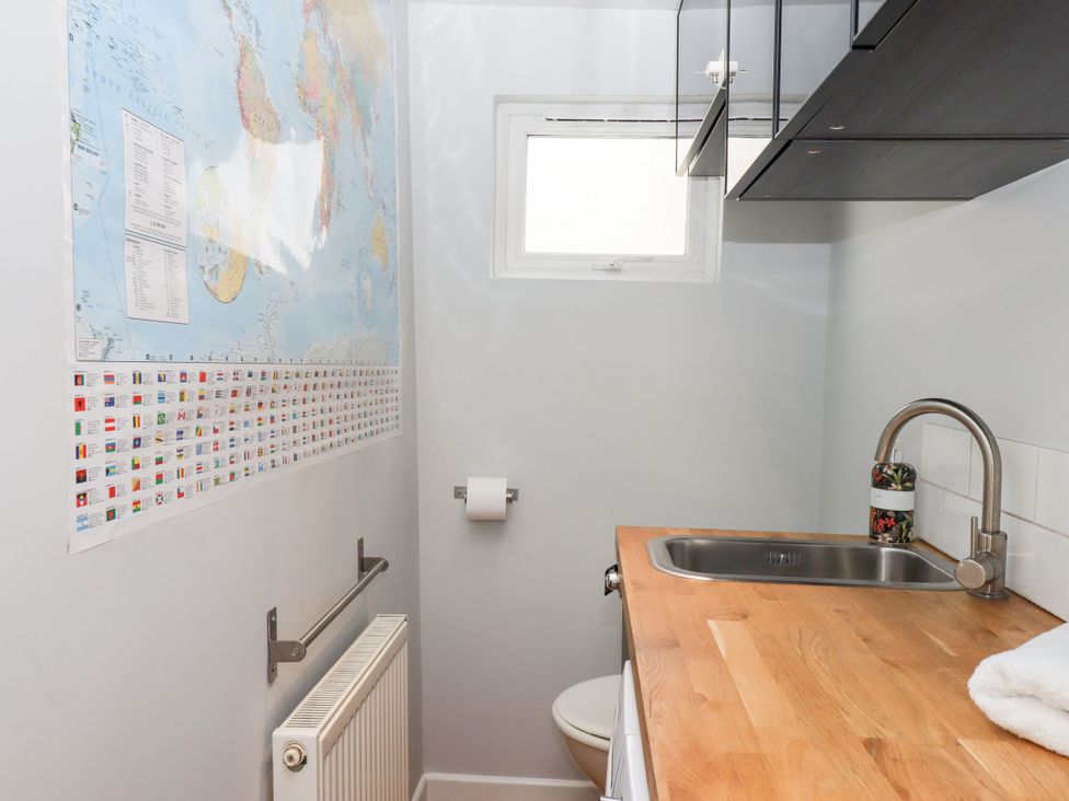 A bathroom with a sink, toilet and a world map at 15 Summerland Avenue, Dawlish