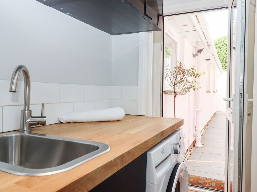 A laundry room with a sink and washing machine at 15 Summerland Avenue Dawlish