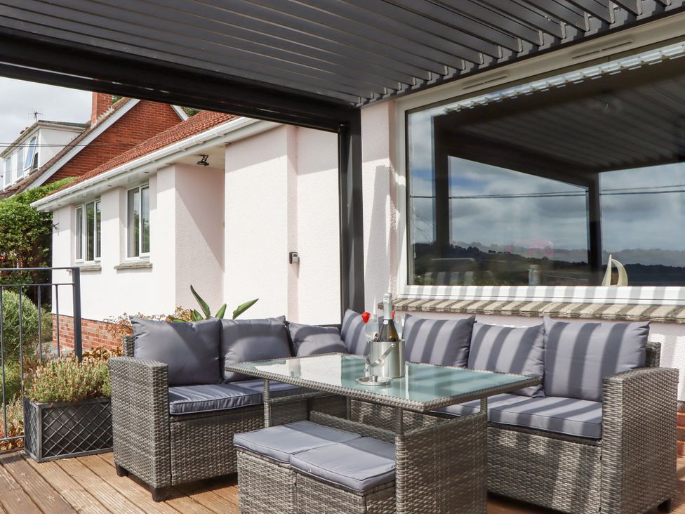 A patio with outdoor seating and a table at 15 Summerland Avenue, Dawlish