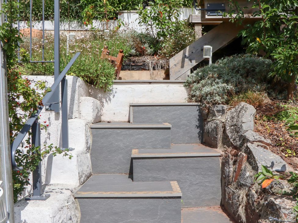 A garden with steps leading to a wooden platform at 15 Summerland Avenue Dawlish
